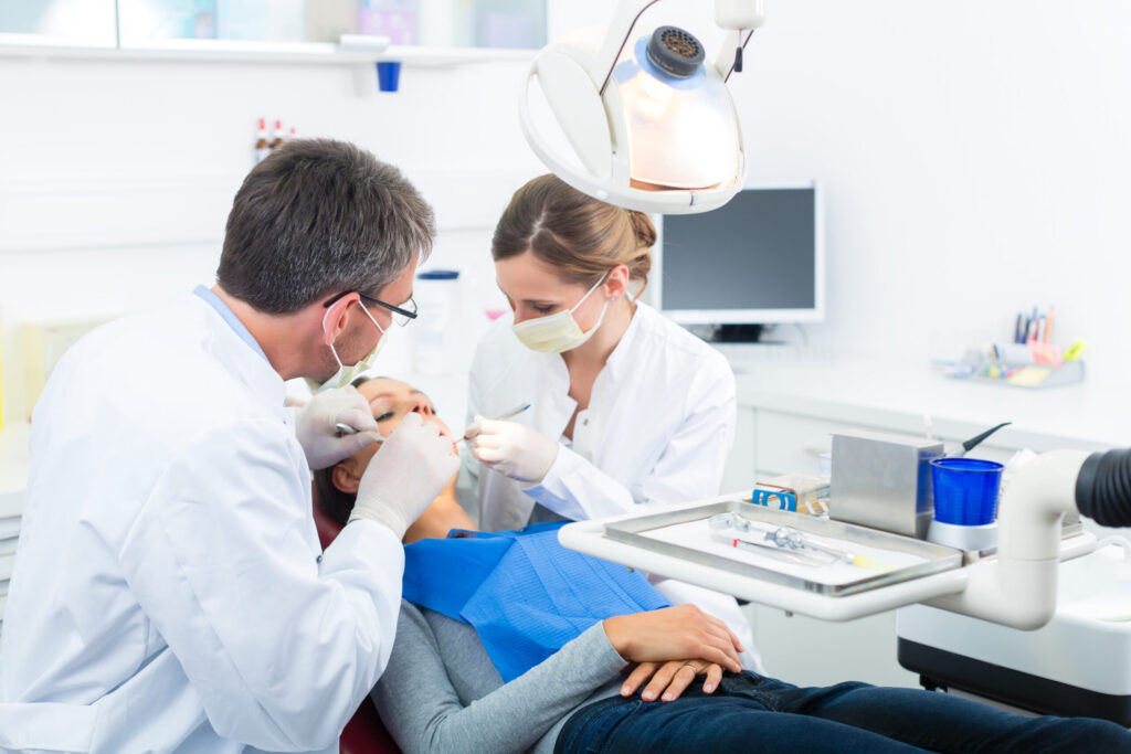 Female,Patient,With,Dentist,And,Assistant,In,A,Dental,Treatment,