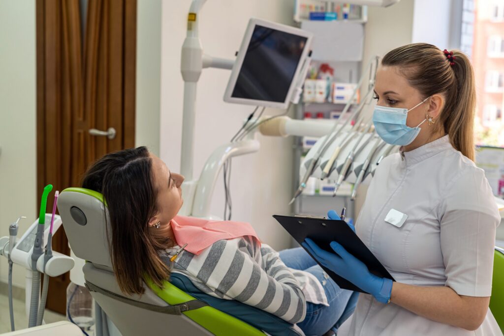 Dentist,With,Tablet,Doing,Consultation,Her,Female,Client,In,Stomatology